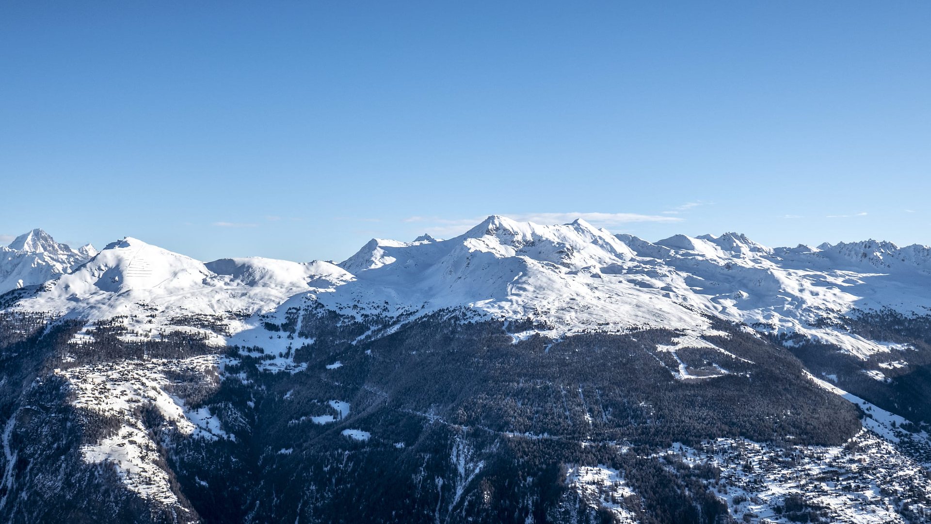 Vue aérienne du domaine skiable de St-Luc – Chandolin sous la neige, face à la chaîne des sommets du val d’Anniviers