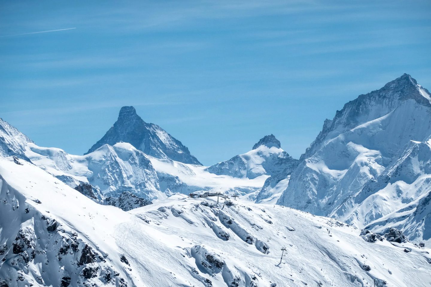 Les sommets des Alpes valaisannes et une installation de remontée mécanique posée sur la crête enneigée