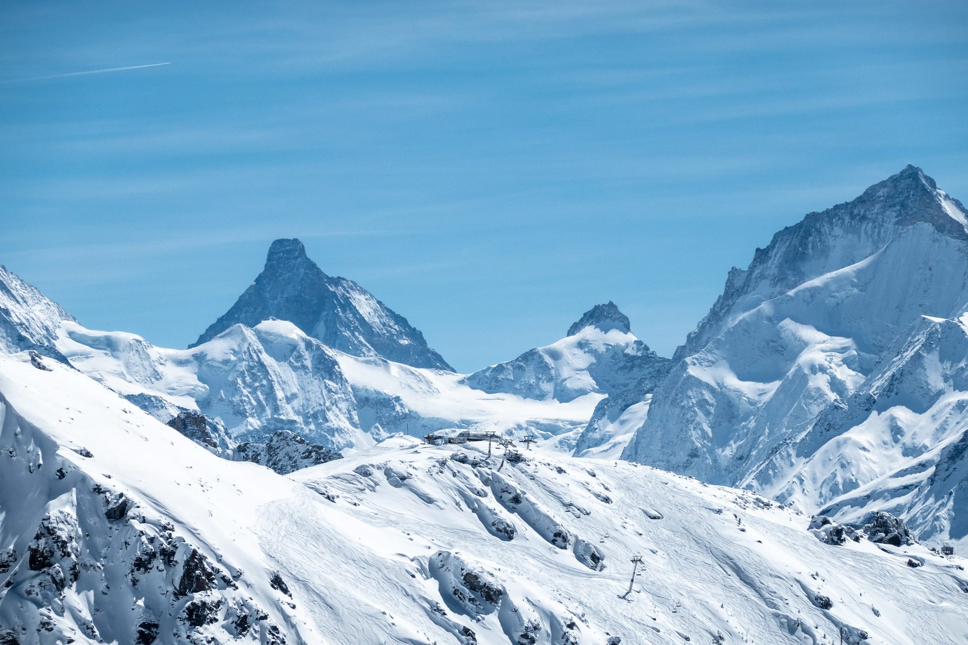 Les sommets des Alpes valaisannes et une installation de remontée mécanique posée sur la crête enneigée